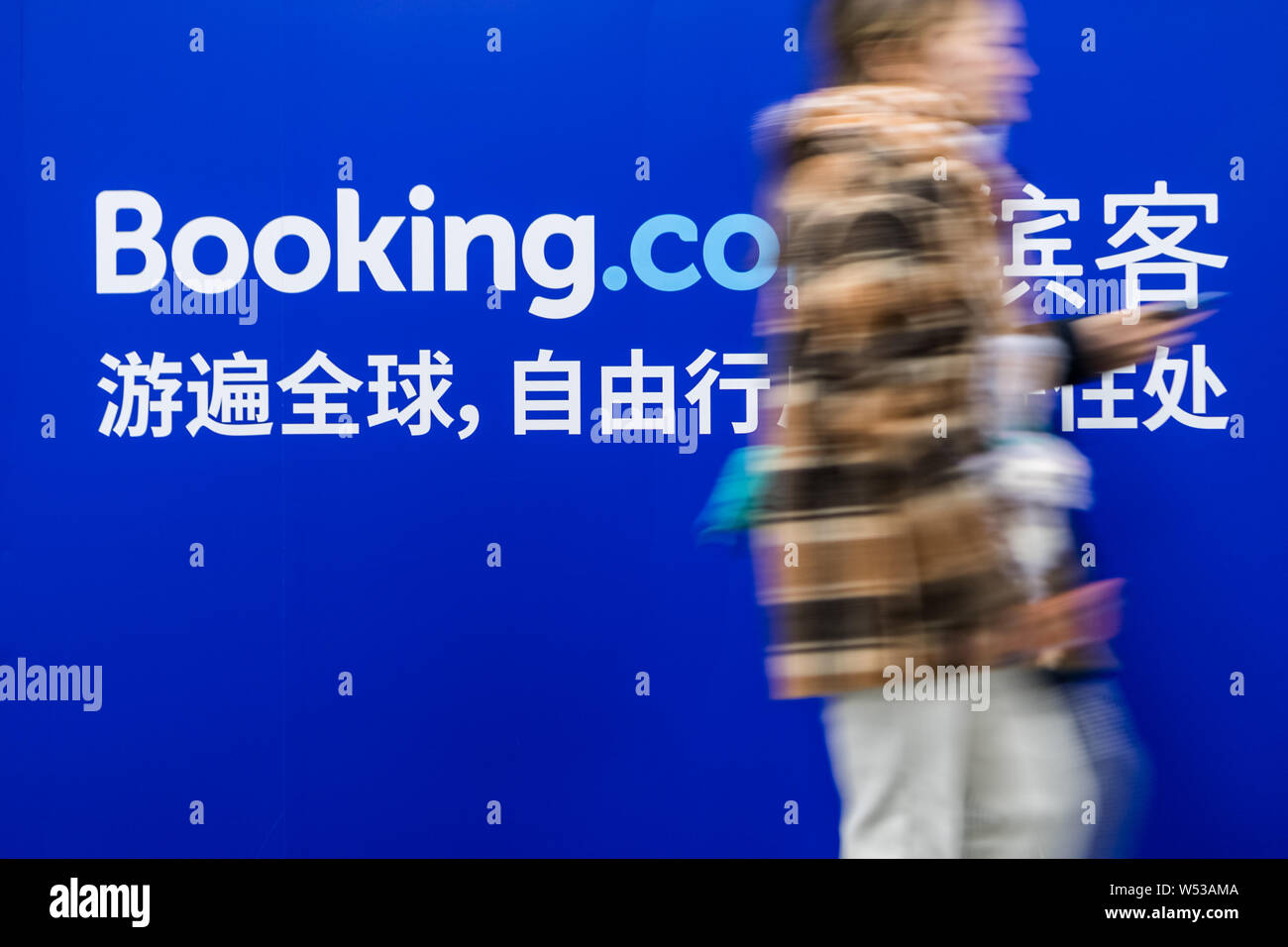Un passager passe devant une publicité pour le site de réservation en ligne Booking.com à une station de métro à Shanghai, Chine, 29 décembre 2018. Booki Banque D'Images