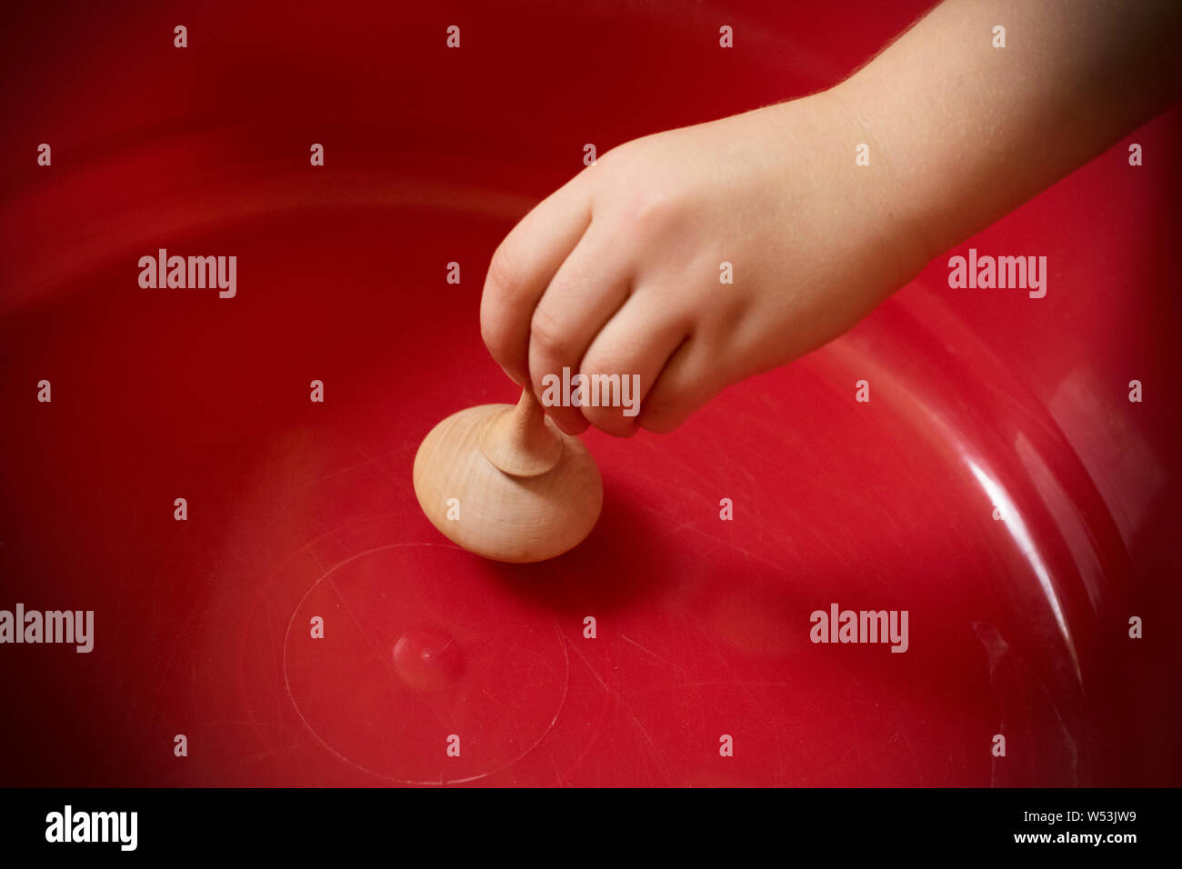 Un gros plan d'une main pour les enfants avec une toupie en bois Photo  Stock - Alamy