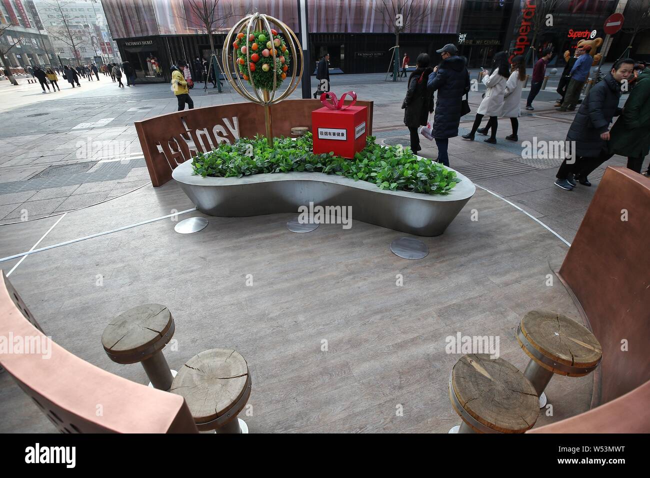 Un grand, grand air fumeurs avec 18 sièges en acier inoxydable, 13 piliers cendrier permanent, six barrières métalliques sur la rue commerçante de Wangfujing j Banque D'Images