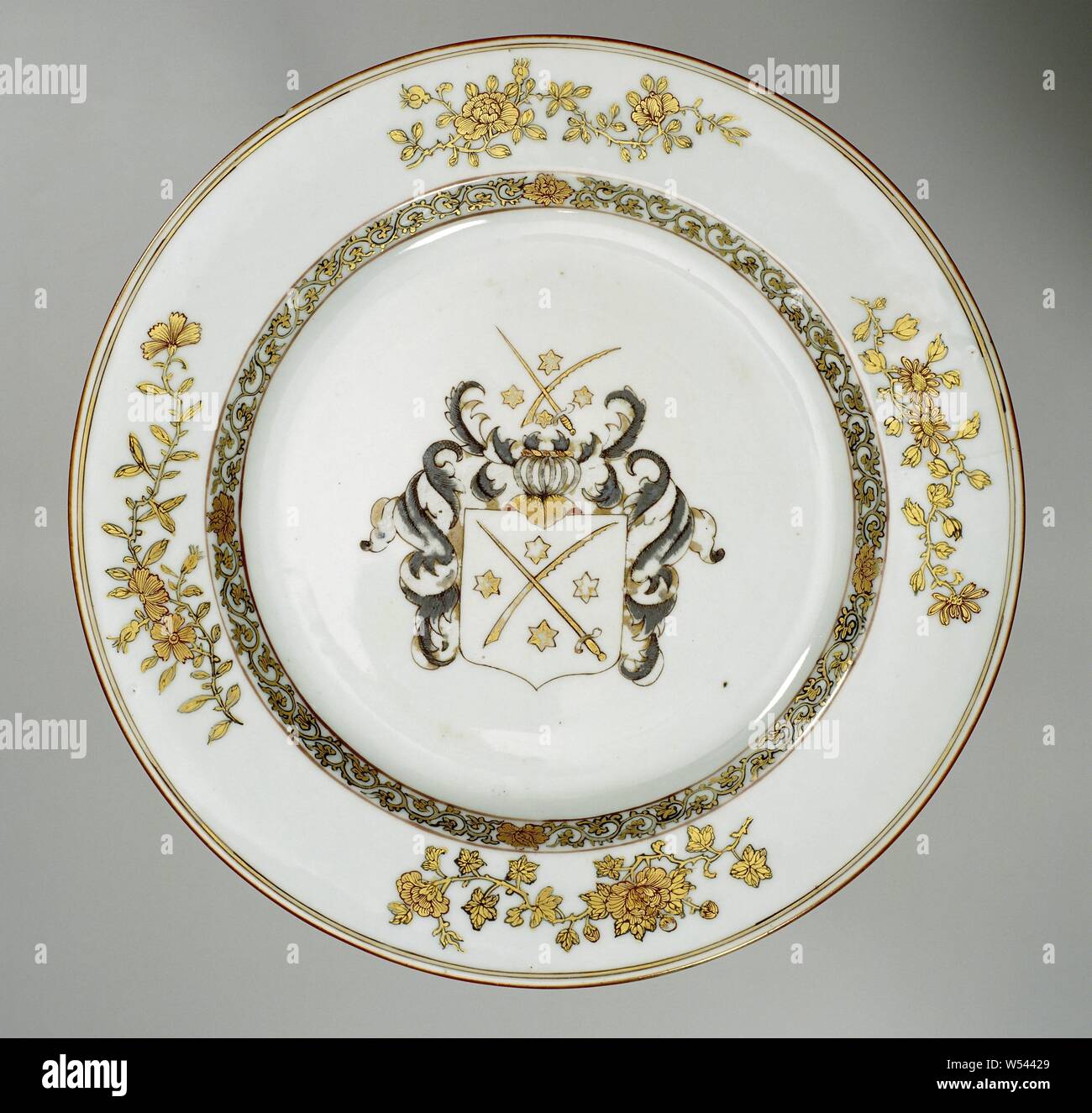 La plaque avec les armoiries de la famille Bijnkershoek, assiette de porcelaine, peint sur la glaçure en rouge, noir et or. Sur le plateau les armoiries de la famille Bijnkershoek. L'arme et le casque de signer se composent d'une épée d'or et de plumes ou de roulement avec des étoiles. Le couvercle se compose de feuilles en noir ou argent et or. Sur le mur une bande morte, avec la frontière avec quatre sprays de fleurs (aster, pivoine, de beaux sportifs). Ancienne étiquette au bas avec 'van Bynkershoek'. Une fissure et une puce dans le bord. Moins la chine porcelaine d'armes nucléaires., anonyme, la Chine, l'c. 1735 - c. 1740, dynastie Qing-(1644-1912 Banque D'Images