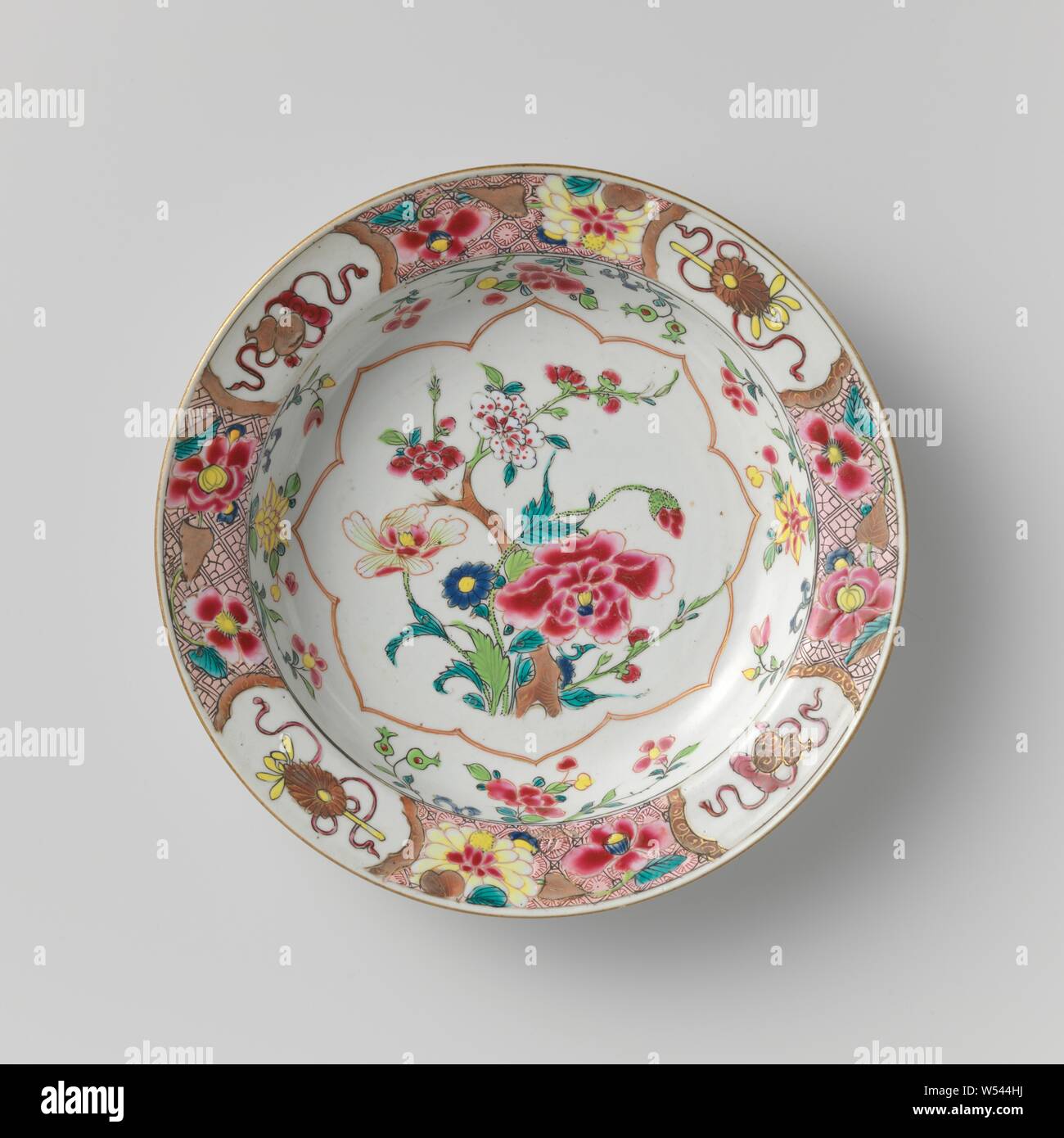 Assiette à soupe avec des plantes à fleurs, les sprays de fleurs et les attributs des Huit Immortels, assiette de porcelaine, peint sur la glaçure en bleu, rouge, rose, vert, jaune, noir et or. Sur l'étagère un cartouche festonné avec un groupe de plantes à fleurs, sur le mur, quatre groupes de plantes à fleurs (pivoines, aster), la frontière avec le travail de serviette à grandes fleurs alternant avec quatre fois les attributs de l'Huit Immortels (tige de lotus, calebasse) en cartouches, lobées l'arrière avec trois fois un champignon lingzhi (). Famille rose., anonyme, la Chine, l'c. 1725 - c. 1749, dynastie Qing-(1644-1912) / période Yongzheng Banque D'Images