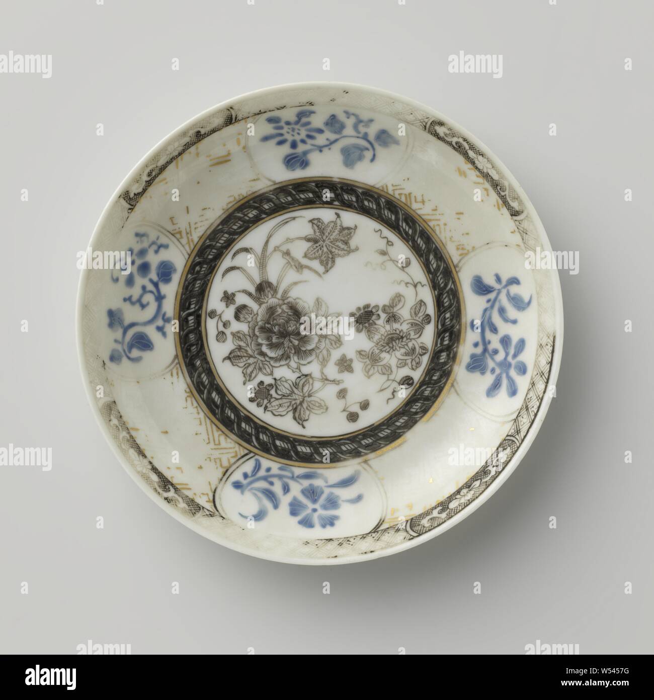 Les sprays de fleurs soucoupe d'ornement et de frontières, plat en porcelaine, peintes sur l'émail en bleu, noir et or. Sur la plaque de l'plat un médaillon avec les sprays de fleurs, bande décorative autour d'elle, sur le mur en or serviette intercalés avec des cartouches avec les sprays de fleurs en bleu, la frontière avec nappes en travail encre alternant avec une vrille lotus encastré dans un cartouche. Encre de Chine., anonyme, la Chine, l'c. 1725 - c. 1749, dynastie Qing-(1644-1912) / Yongzheng-période (1723-1735) / période de Qianlong (1736-1795), Porcelaine, glaçure (matériel), de l'or (métal), la vitrification, H 1,9 cm d 11,7 cm d 6. Banque D'Images