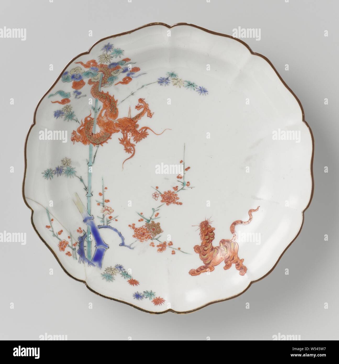 Plat de homard avec Dragon, Tigre, bambou et prunus, assiette de porcelaine avec un bord lobé, peinte sur l'émail en bleu rouge, vert, jaune, noir et or avec un tigre près de prunus, jusqu'à la à un enroulement dragon autour d'un bambou. Border Brown. Quatre proen dans le socle. Theodore Kakiemon, Jean Royer, anonyme, le Japon, l'c. 1670 - c. 1690, période Edo (1600-1868), porcelaine (matériau), glaçure, dorure, H 3,5 cm d 18 cm Banque D'Images