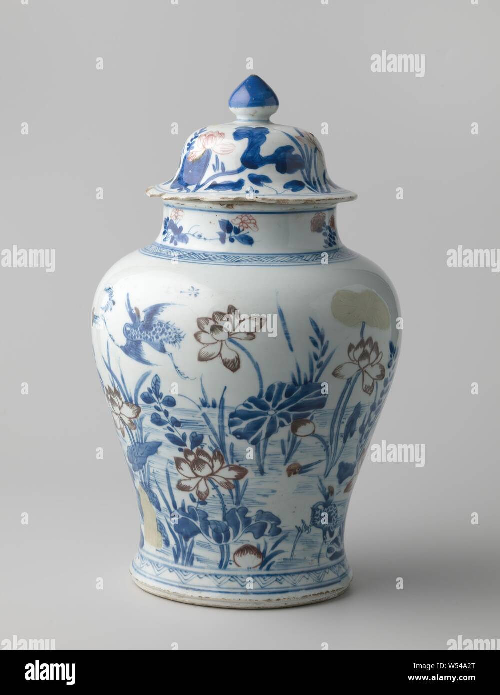 Pot balustre couvert avec lotus plantes et de grues, de balustres en porcelaine en forme de pot avec une propagation et un large cou. Décor peint en bleu et rouge et un blanc de la boue. Sur le mur une représentation continue d'un étang avec lotus pour les plantes et au comité permanent et Flying Cranes. Bande décorative autour du pied et de l'épaule. Le cou avec les sprays de fleurs. Lotus sur le couvercle des plantes. Quelques fissures dans le cou du pot, le bord du couvercle avec des puces multiples. Inscrite sur le fond avec une feuille d'armoise dans un double cercle. Le décor sous glaçure bleu avec le cuivre rouge., anonyme, la Chine, l'c. 1700 - c. Qing, 1724 Banque D'Images