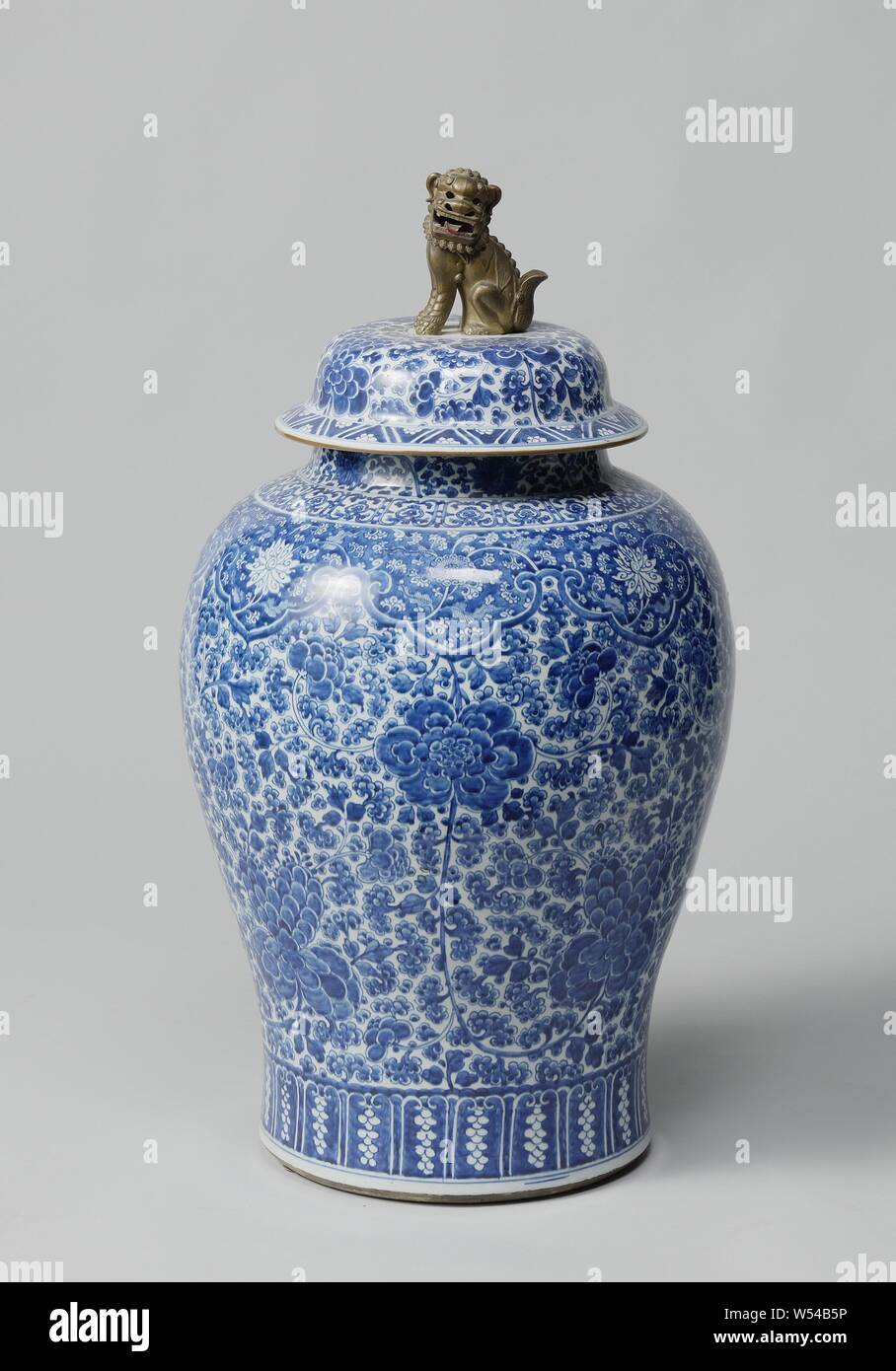 Paire de vases balustre couverts lidded jar, avec des parchemins, de balustres en porcelaine en forme de pot couvert, décor peint en bleu. Le corps est entièrement recouvert d'une vigne de fleur de pivoine (continu). Sur l'épaule avec une bande enregistrée avec lambrequins et fleurs de lotus vignes sur un fond bleu. Au-dessus du pied un groupe avec des motifs de feuilles stylisées. Le cou avec vrilles lotus. Le couvercle avec bouton de couvercle morte, sous la forme d'un bronze plaqué or, shishi. Inscrite sur le fond avec un numéro gravé Johanneum 'N393' au-dessus d'une ligne ondulée. Bleu Blanc., anonyme, la Chine, l'c. 1700, dynastie Qing- Banque D'Images