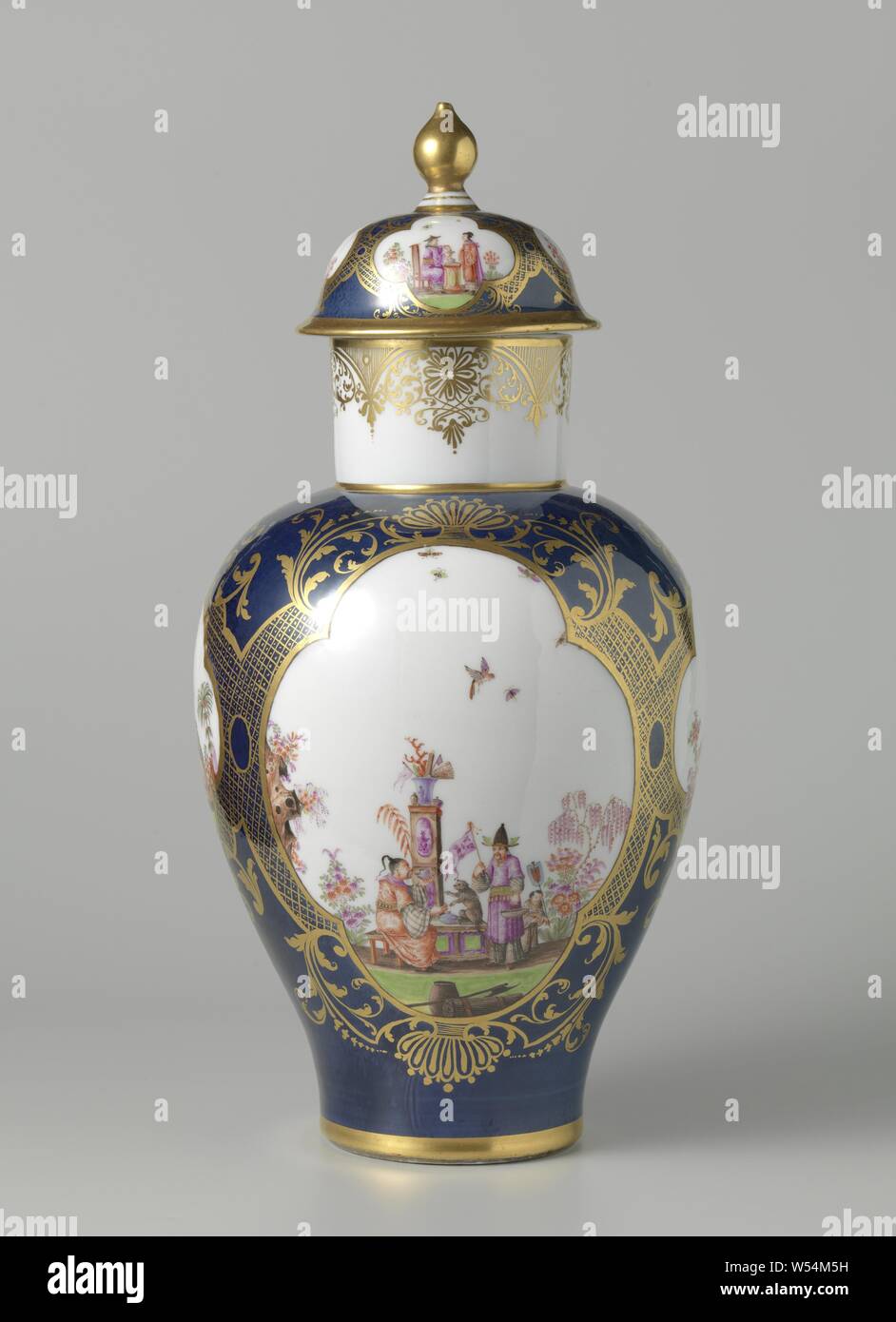 Vase à couvercle Vase avec couvercle Vase avec couvercle, multi-couleur peint avec des chinoiseries en quatre étapes de l'encastré un fond bleu, Vase avec couvercle, faites de porcelaine peintes multicolores. Vase et le couvercle sont presque entièrement recouverte d'un fond bleu, dans lequel deux grands et deux petits et quatre étapes quatre étapes sont enregistrés sur le vase. Un ornement symétrique est peint en or entre les quatre passages. Höroldt chinoiseries sont peints dans un jardin dans les quatre passes. Le bouton de porte en forme de poire est plaqué or. Le vase est marquée., Meissener Porzellan Manufaktur, Meissen, ch. 1735 - c. 1740, porcelaine Banque D'Images