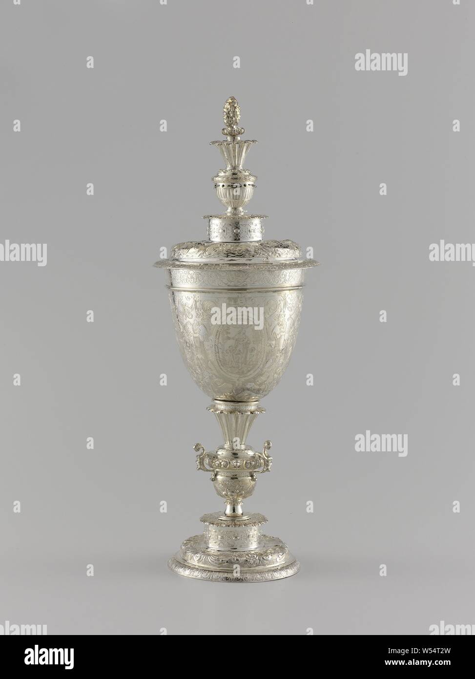 Gobelet, gobelet ou sacrement tasse en argent, en forme de balustre sur un tronc avec un couvercle. La tasse en forme d'œuf est gravé de cartouches dans lesquels, Spes Fides et Charitas (la foi, l'espérance et l'amour), l'ornement, grotesque, charité, 'Caritas', 'Carità' (RIPA), l'une des trois vertus théologales, anonyme, Clèves, ch. 1600 - c. 1625, de l'argent (métal), gravure, h 38,7 cm H 25 cm d 11,6 cm d 13,7 cm d 11,9 cm w 827 w 563 gr Banque D'Images