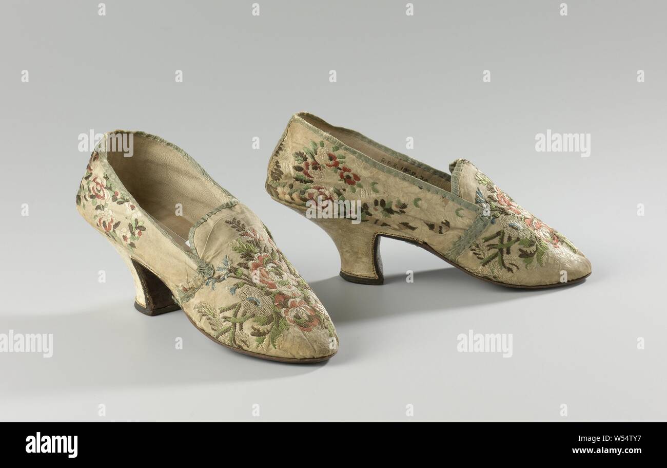 Des chaussures de soie brodée avec un fond de couleur crème avec des bouquets de roses et de fleurs, des chaussures de soie brodée avec un fond de couleur crème avec des bouquets de roses et de fleurs. Modèle : Le nez arrondi est un avant et un arrière. L'avant du talon s'exécute directement vers le bas à angle droit de la geleng. Le côté et l'arrière sont montés et recouverts de cuir de couleur crème. Coutures de couleur or s'étend le long du bord du talon. Le talon a une jante en cuir brun foncé de l'arrière. Dos en cuir et semelle en cuir. Capot arrière et capot avant bordées de lin. Banque D'Images
