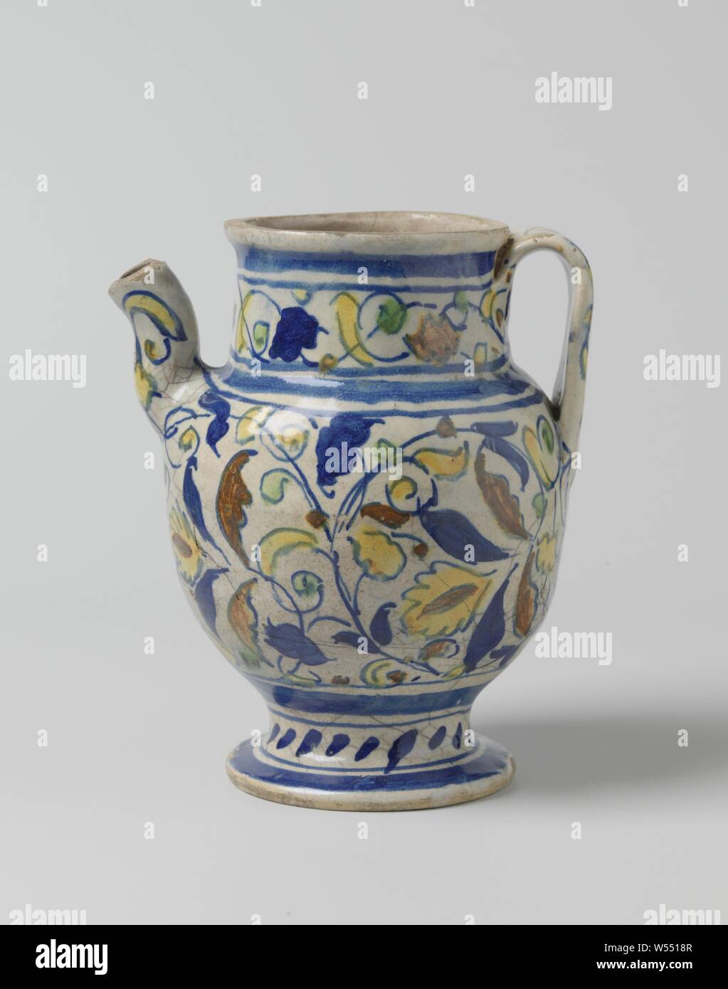 Sirop peut de majolique peint multicolores, le sirop peut de majolique peint multicolores. La verseuse a un ventre rond, un large cou cylindrique et se tient sur une base ronde. L'oreille est en forme de c et le court bec verseur est en forme de s. La verseuse est peint avec des feuilles et bandes bleu le long du cou et pied., anonyme, Anvers, c. 1525 - c. 1575, faïence, émail étain, plomb glaze, H 20 cm × 16 cm × w d 13 cm Banque D'Images