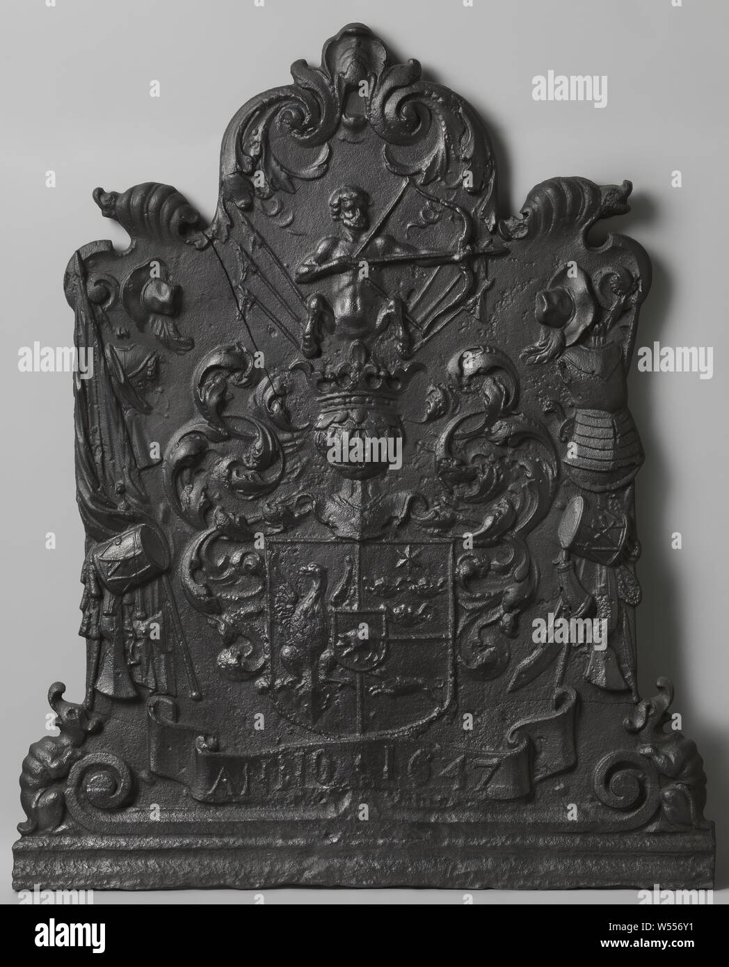 Plaque de feu avec le blason de la famille de Joan Huydecoper, plaque de feu en fonte. Le blason de la famille de Joan Huydecoper est centrale : un bouclier avec un aigle à gauche, une étoile à six pointes et trois crânes de boeuf en haut à droite et un Greyhound sautant en bas à droite. Il y a un cochon dans le cœur la protection. Au-dessus de l'écu sommé d'un casque parmi un feuillage, au-dessus duquel un centaure avec un arc et flèche. Des deux côtés d'un festival d'armes et en bas une banderole avec l'inscription ANNO 1647. Créatures grotesques sur les coins inférieurs. L'ornement au sommet est travaillé dans le style du lobe, Joan Banque D'Images