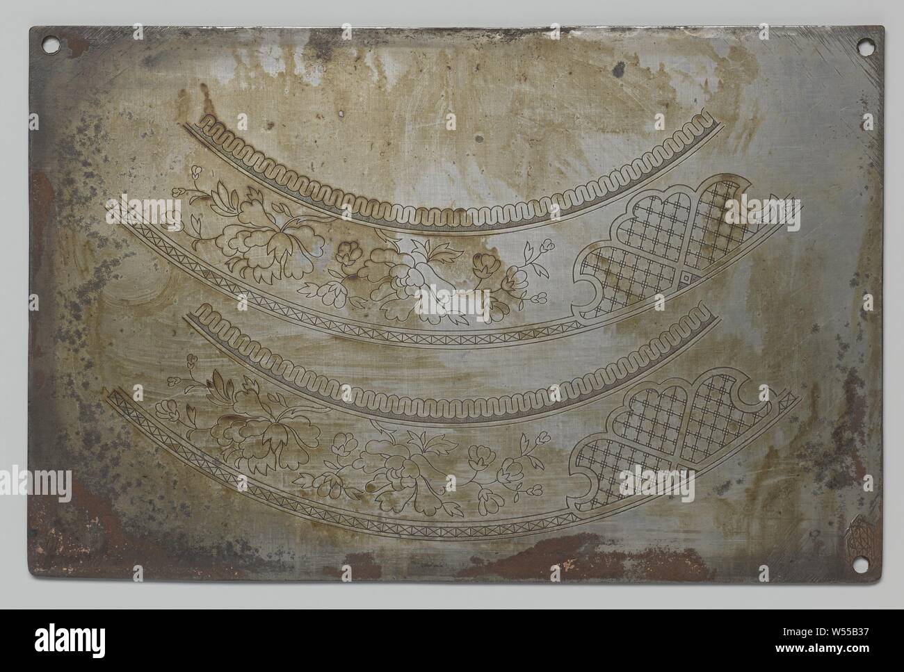 La plaque avec des décorations gravées pour la poterie, avec des fleurs et des enfants, la plaque de cuisson avec du cuivre gravé des représentations. D'une part avec deux décorations avec des fleurs à la frontière pour une assiette. Dans le coin en haut à droite, le texte : RIJSBORD 11 rand (un 0 barré) DM. L'autre côté avec décorations pour un sucrier : feu, enfants jouant avec un bateau et une jeune fille jouant avec un chien. Dans le coin en haut à droite, le nombre 1219. Aussi cinq timbres d'usine, dont trois ont été biffés. Il y a des trous forés dans trois des coins., Petrus Regout, Maastricht, ch. 1801 - c Banque D'Images
