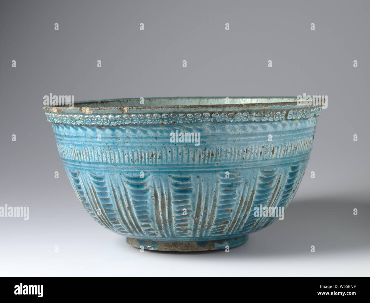 Bol avec un insiced avec bol en poterie, décoration d'azur à glaçure. Décoré à l'extérieur horizontal et vertical avec alternance de bandes décoratives gravées. Ci-dessous la partie externe d'une ligne ondulée et des cercles concentriques concaténées sur le bord lui-même. Dans la partie inférieure de l'intérieur un certain nombre de bicarbonate de coquelicots., anonyme, l'Iran, ch. 1600 - c. 1799, Grès, glaçure, la vitrification, H 16 cm d 31,5 cm d 14 cm Banque D'Images