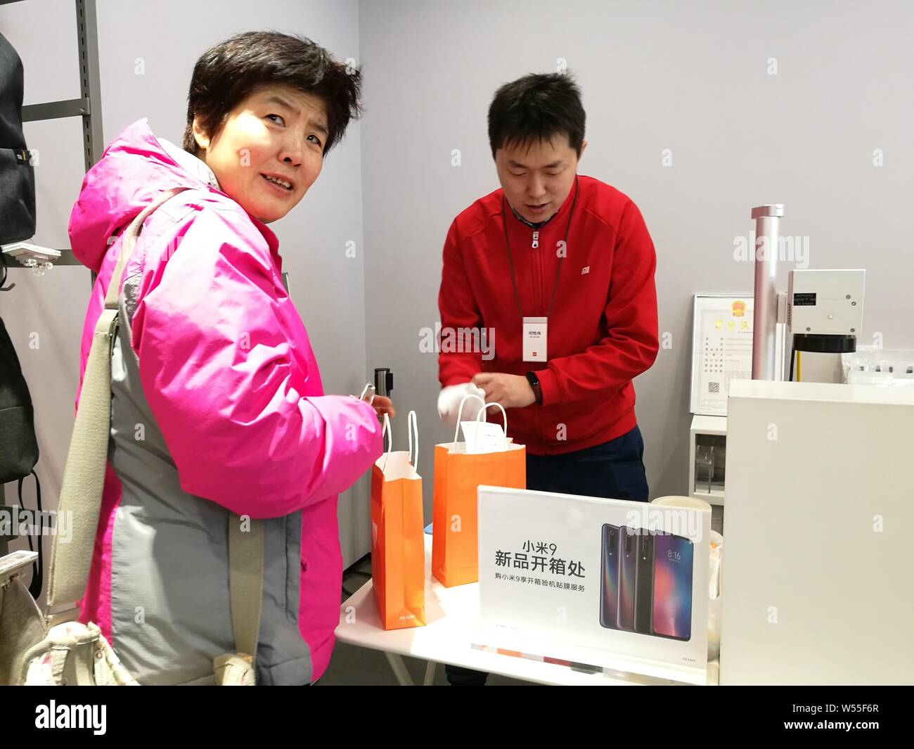 Un client montre son smartphone Xiaomi Mi 9 dans un magasin de Xiaomi à Beijing, Chine, 26 février 2019. Banque D'Images