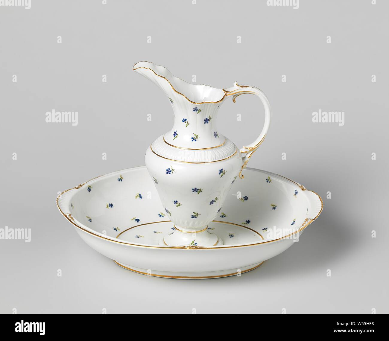 Verseuse en porcelaine et bassin, bassin et verseuse peinte avec un modèle de dispersion des barbeaux bleu et or sur les bords de la tuyauterie. Marqué : M.O.L. et Amstel en bleu sous glaçure. Le plat ovale a ornements rocaille le long du bord, qui sont déformés dans les axes longitudinal et sont parées d'or. La verseuse avec un ventre en forme de cône, un large qui dépasse la buse avec un contour ondulé et une oreille en forme de rocaill gaufré a-feuille de vigne le long du pied et le cou et est garni d'or sur tous les bords., Manufactuur Oud-Loosdrecht, Loosdrecht, 1784, porcelaine (matériau), d 8,5 cm h 24,5 cm H 7 cm × w 34 cm Banque D'Images