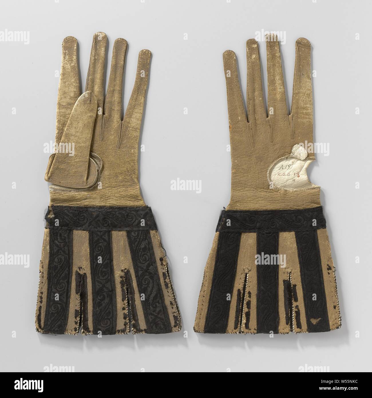 Gant de chèvre ( ?), en cuir de couleur ocre avec incisée, bouchons desserrés décoré de ruban de satin noir brodée d'un motif floral de soie noire, chèvre de droite ( ?), gant de cuir noir ornée de bouchons desserrés ruban satin brodée d'un motif floral en soie noire. Modèle : Doigts longs et étroits avec l'exécution de couture à travers le dessus de la main pour créer l'illusion d'encore plus de doigts. Le pouce est partiellement détaché. Cousue avec de la soie verte. Les bouchons desserrés sont mis sur le gant avec les points de suture de soie jaune. Ces couvercles sont renforcées avec trois couches de papier gris et à l'origine bordé Banque D'Images