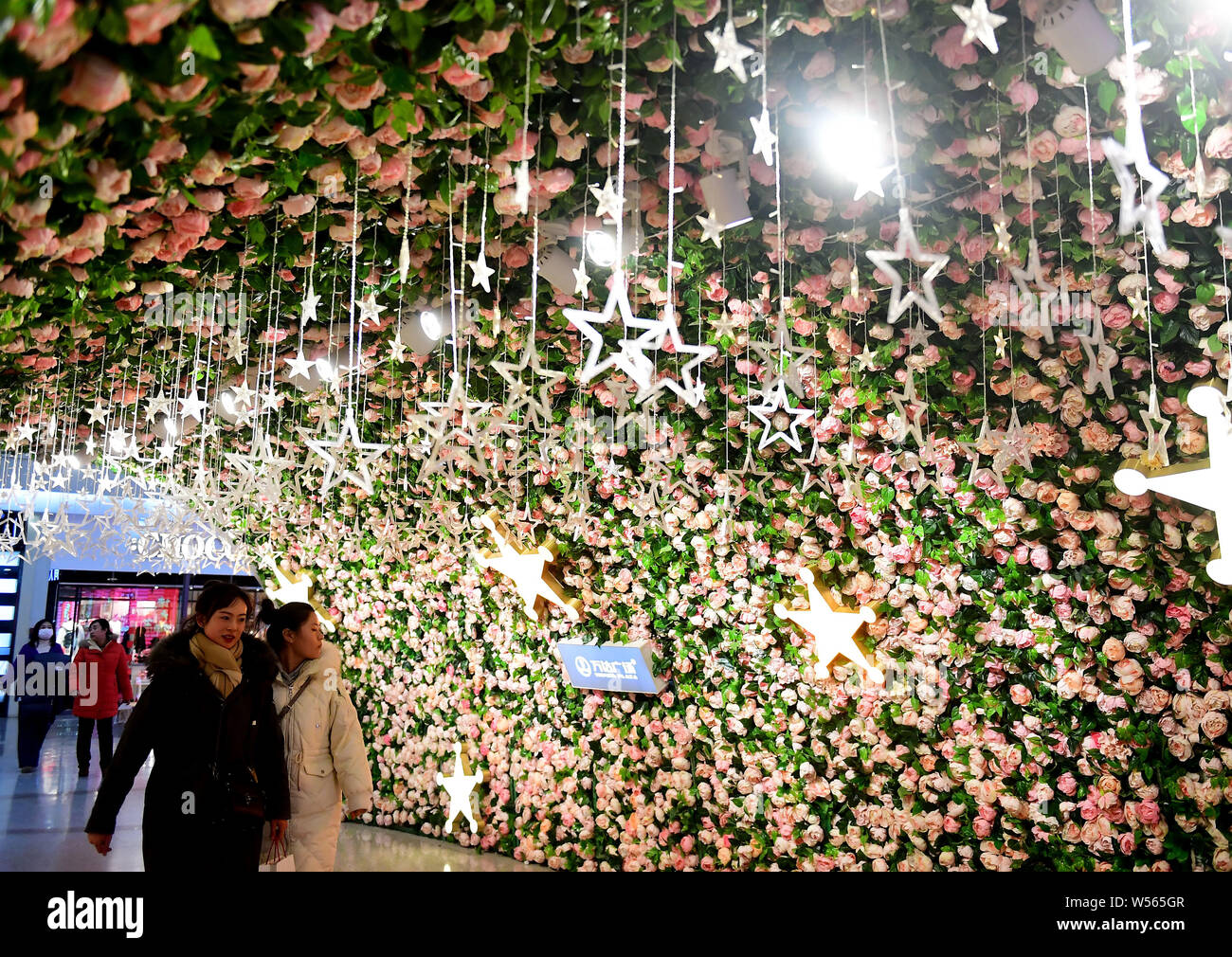 Un couple d'amoureux de promenades à travers un tunnel décoré de fleurs en avant de la Saint-Valentin à Shenyang city, Liaoning Province du nord-est de la Chine, 1 Banque D'Images
