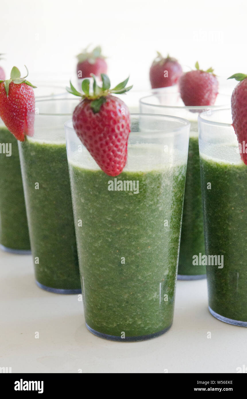 Régime alimentaire végétalien premières.Green smoothies verre avec garniture aux fraises. Banque D'Images