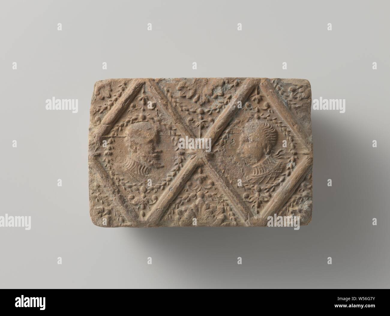 Cheminée de terre cuite au four avec la division en forme de losange avec deux médaillons d'un homme et femme, cheminée de terre cuite en forme de losange avec division. Deux médaillons d'un homme et une femme., anonyme, Pays-Bas du Sud, ch. 1400 - c. 1950, argile, H 9,5 cm × 14,5 cm × t w 6 cm Banque D'Images