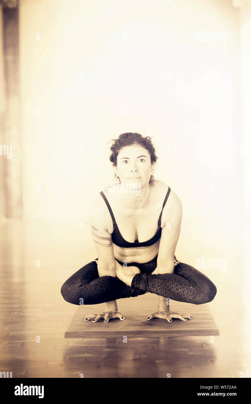 Hispanic woman practicing yoga in studio photographié en noir et blanc. Banque D'Images