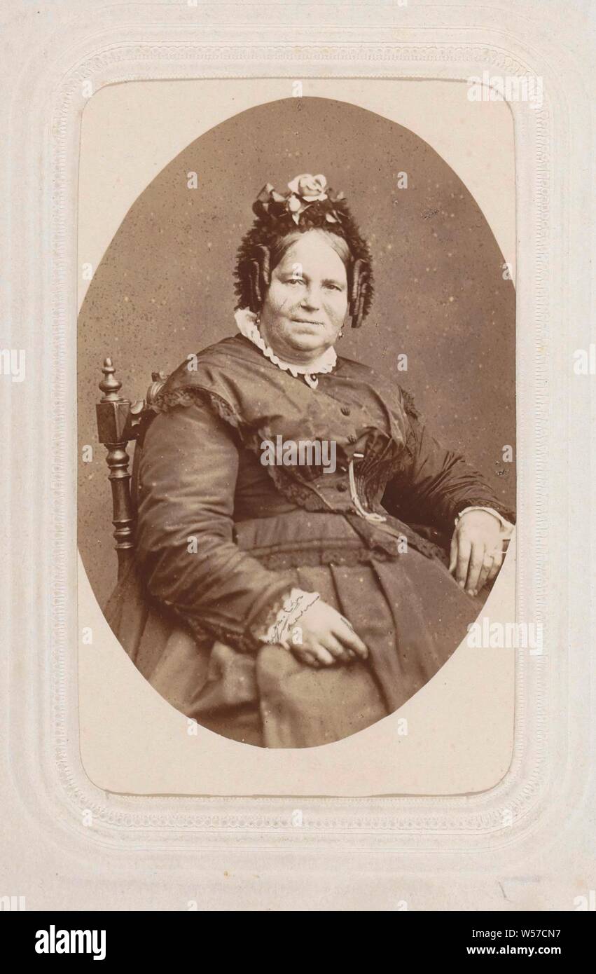 Portrait d'une femme assise avec un tuyau se courbe et pac, partie d'album photo avec 26 cartes de visite des membres du clergé catholique., robe, robe, chef-d'engrenage : cap, styles ou hairdress - AA -, les femmes, studio, photographe, Maastricht, Théodor Weijnen, ch. 1860 - c. 1870, carton, papier, papier photographique, à l'albumine, h 89 mm × w 56 mm Banque D'Images