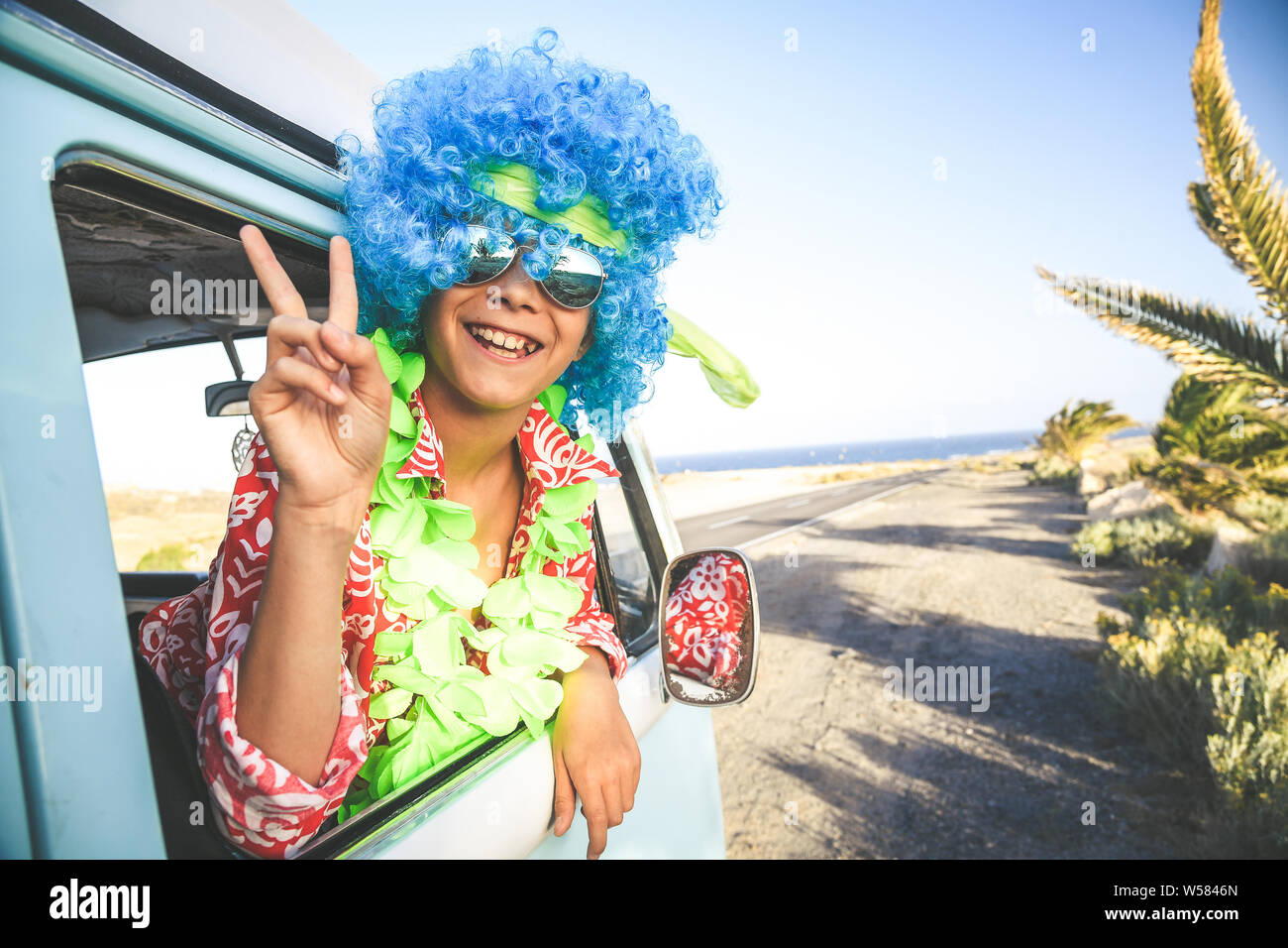 Jeune homme drôle fou avec perruque bleu, chemise rouge avec des fleurs  blanches et vert acide hawaii collier enfant drôle déguisement prêt  célébrer le jour d'imbécile d'avril Photo Stock - Alamy