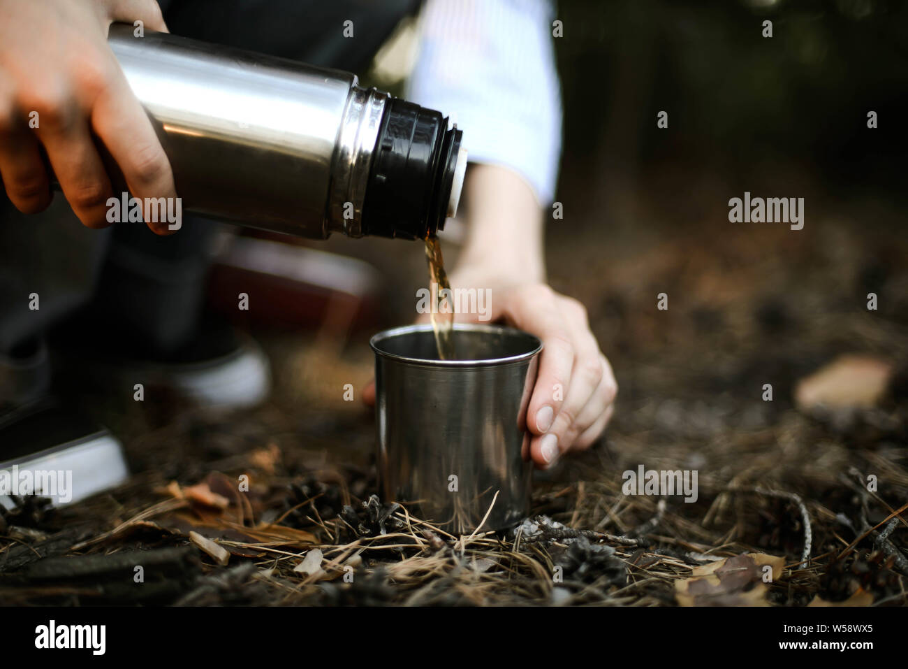 Close-up of woman pouring plateau de verre isolé contenant int Banque D'Images