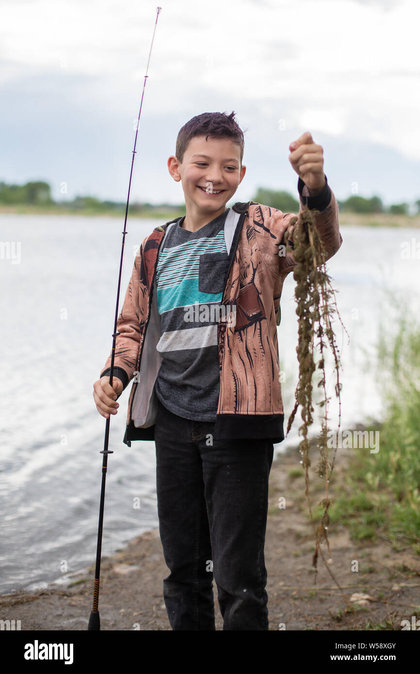 Garçon riant de pêche lors de l'algue Banque D'Images
