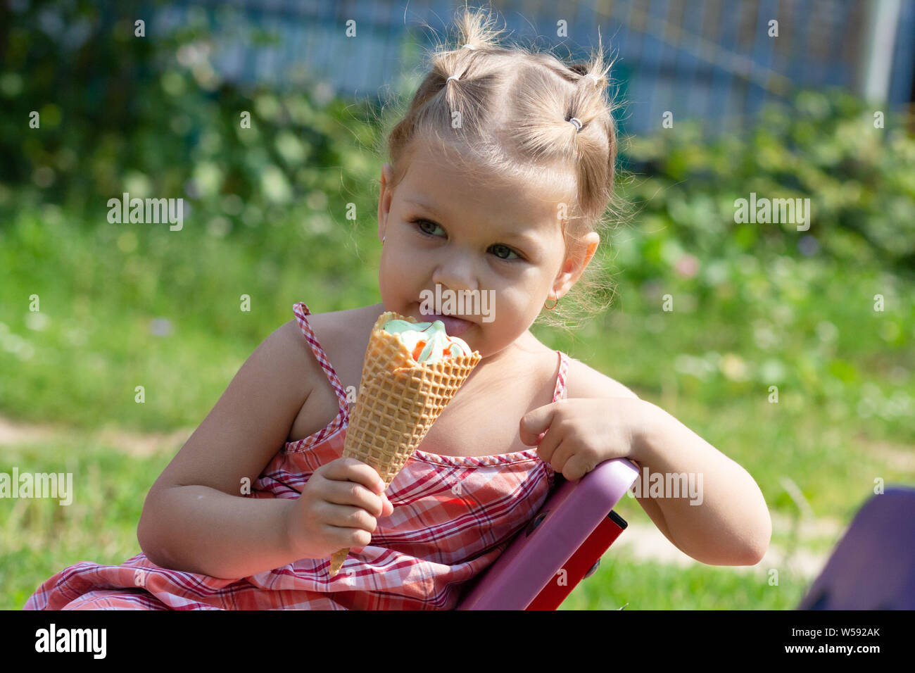 Happy little girl eating waffle corne de crème glacée au parc d'été Banque D'Images