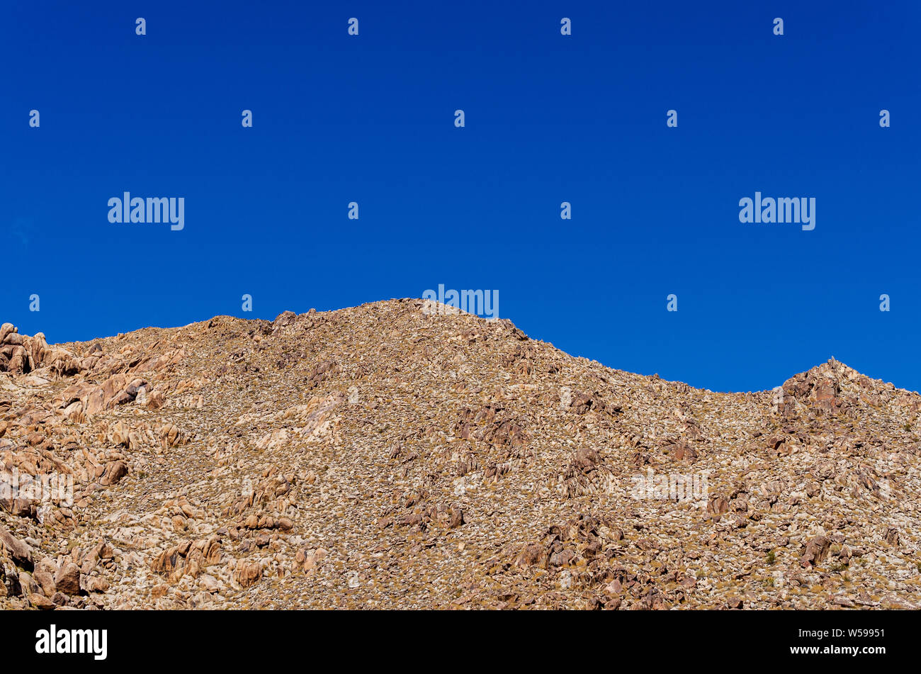 Brown mountain peak stérile sous un ciel bleu lumineux. Banque D'Images