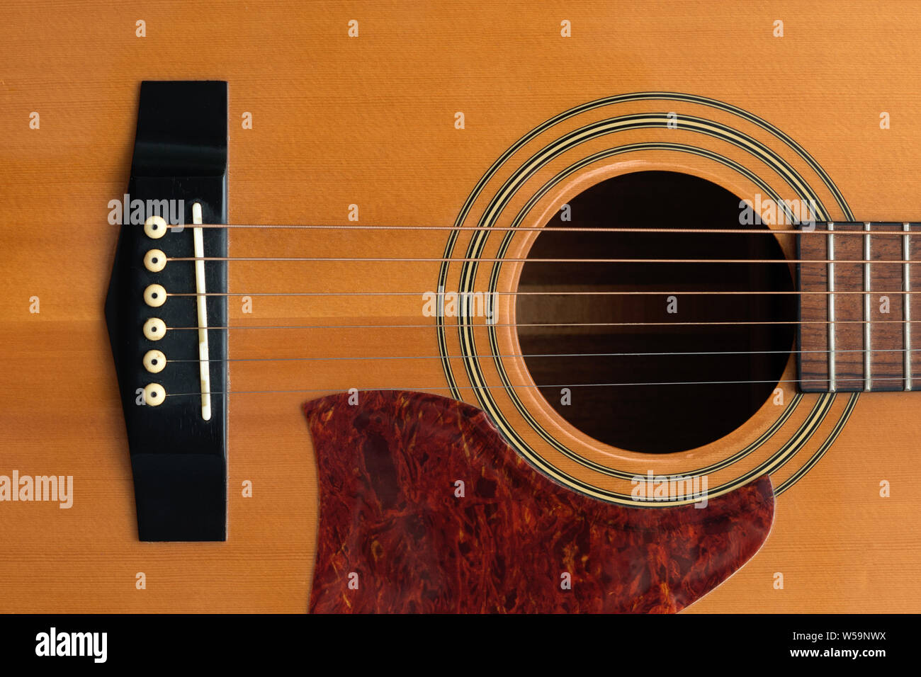 Fermer macro-vision des frettes les six et le son trou sur un corps de guitare en bois acoustique Banque D'Images