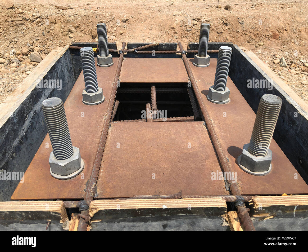 Le coffrage et le renforcement de fondation en béton armé avec des boulons d'ancrage métallique destiné à l'installation de colonnes métalliques. Banque D'Images Le coffrage et le renforcement de fondation en béton armé avec des boulons d'ancrage métallique destiné à l'installation de colonnes métalliques. Banque D'Images