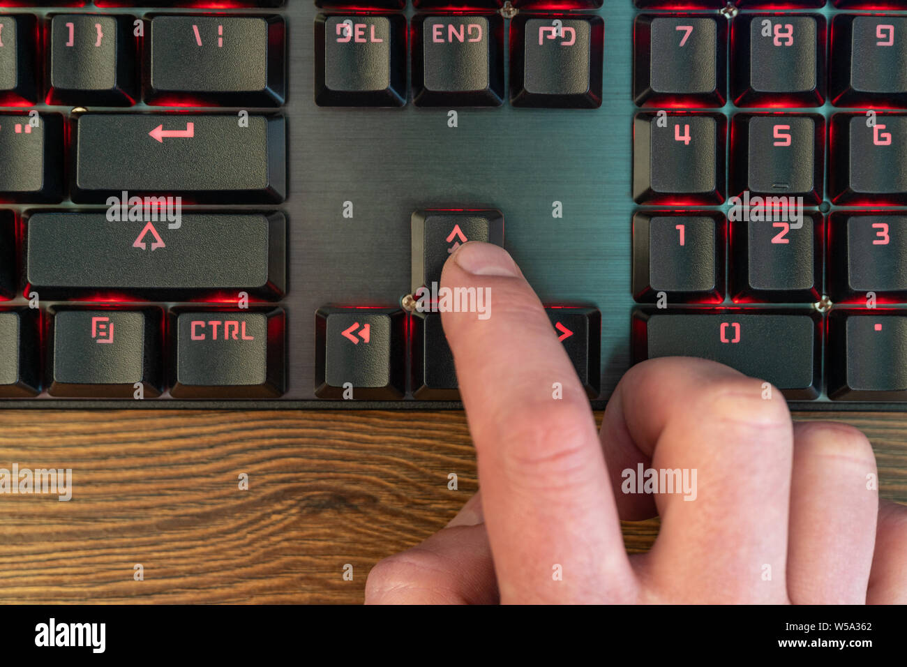 Man main doigt appuie sur la flèche haut du clavier étendu sur une table en  bois, close-up Photo Stock - Alamy