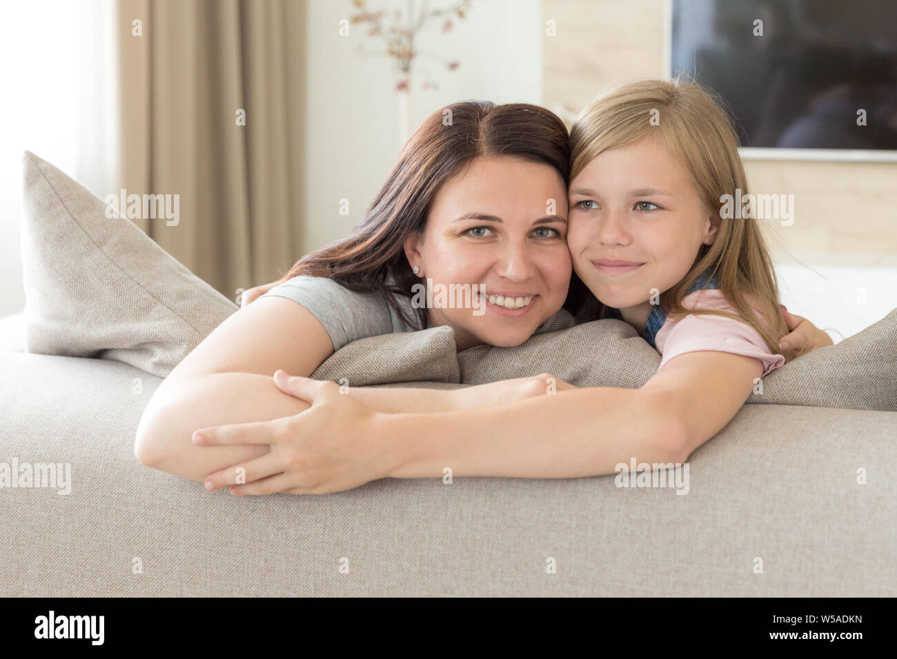Mère et fille Pré-ado assis sur la table en souriant. Concept de famille heureuse Banque D'Images
