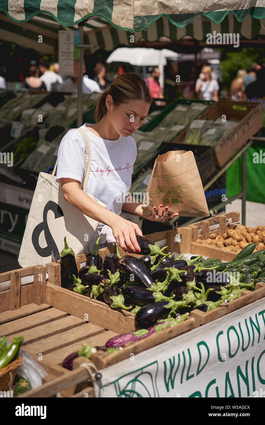 Londres, UK - juillet 2019. Shopping jeunes légumes organiques dans un marché fermier local à Brockley, Sud-Est de Londres. Banque D'Images