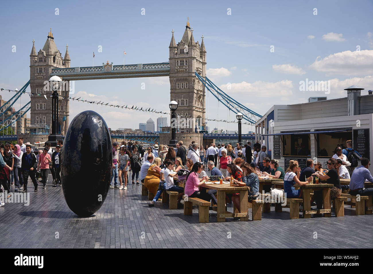 Londres, UK - juillet 2019. Les personnes ayant des boissons dans une fenêtre pop-up bar créé pour l'été par la rivière qui a eu lieu près de l'Hôtel de Ville et le Tower Bridge. Banque D'Images
