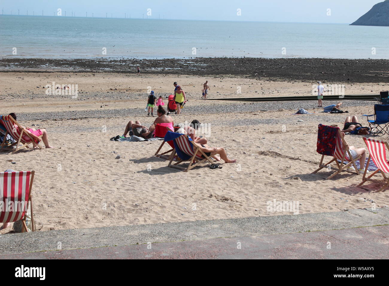 Les vacanciers profitant du beau temps sur la plage de Llandudno, au Pays de Galles Banque D'Images