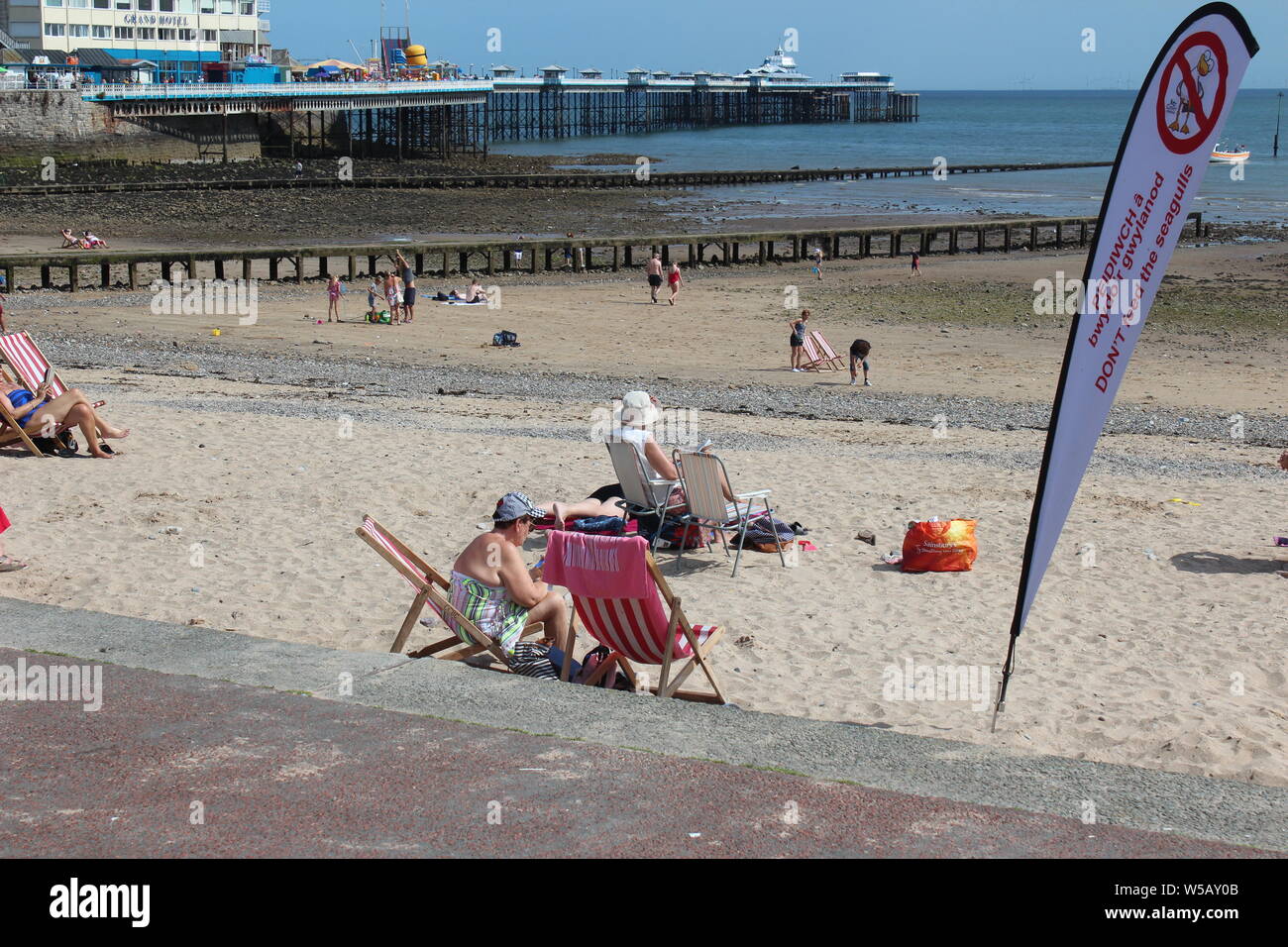 Les vacanciers profitant du beau temps sur la plage de Llandudno, au Pays de Galles Banque D'Images