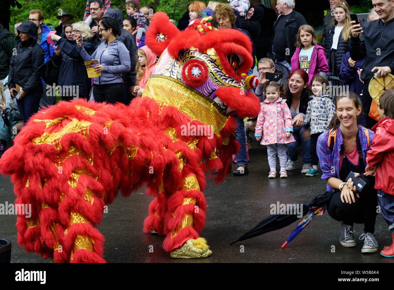 Dragon chinois rouge devant une foule de personnes au Valley Gardens Carnival, Valley Gardens, Harrogate, North Yorkshire, Angleterre, ROYAUME-UNI Banque D'Images