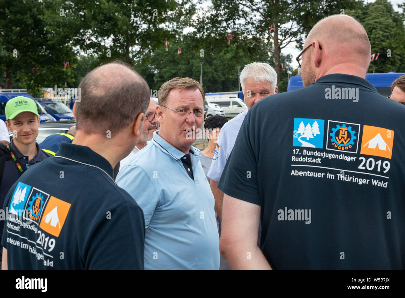 Rudolstadt, Allemagne. 27 juillet, 2019. Bodo Ramelow, Linke (M), premier ministre de la Thuringe, de discussions avec les organisateurs du camp de jeunes 2019 Fédéral THW. Autour de 5000 jeunes de toute l'Allemagne en concurrence à l'échelle fédérale des jeunes Camp de l'organisme de secours technique (THW) dans les premiers secours, soins des blessures et de la transformation du bois des compétitions. Crédit : Michael Reichel/dpa/Alamy Live News Banque D'Images