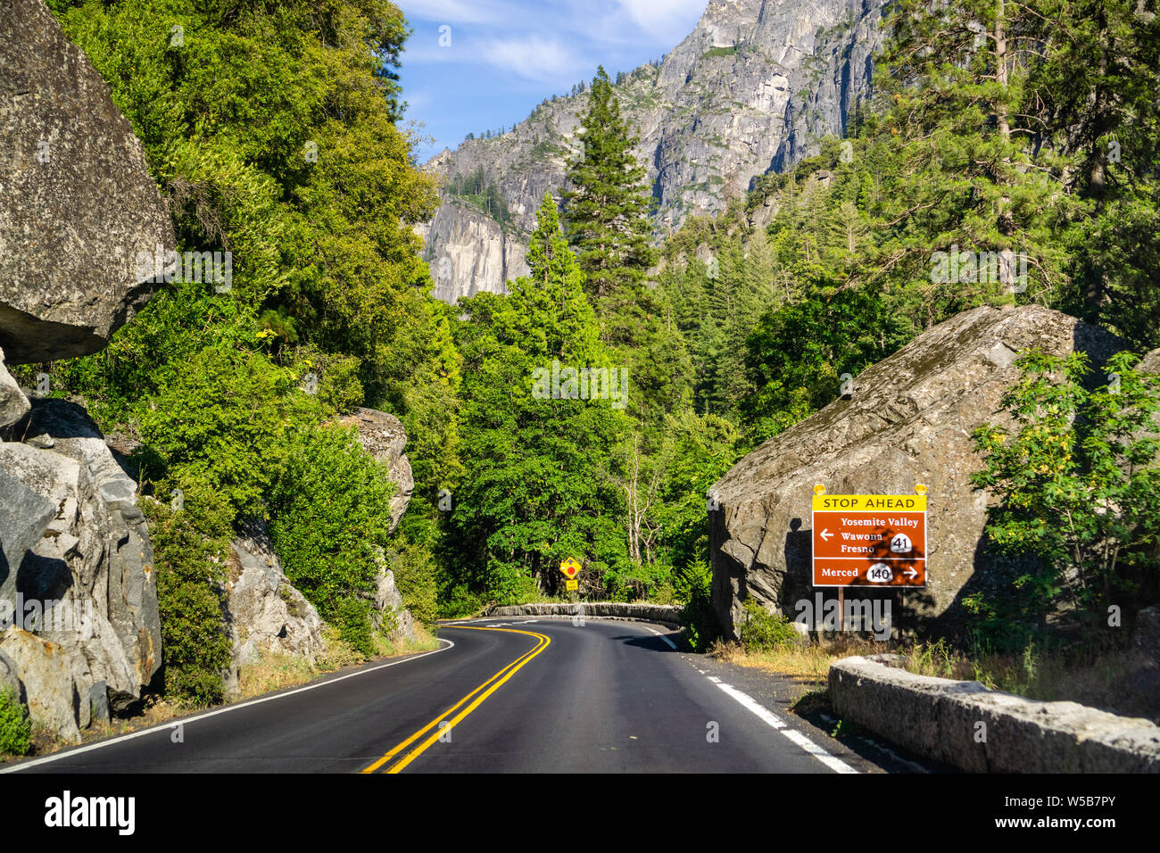 Panneau routier posté sur l'autoroute 120 avec arrêt de l'avant et d'avertissement directions ; Yosemite National Park, la Sierra Nevada, en Californie Banque D'Images
