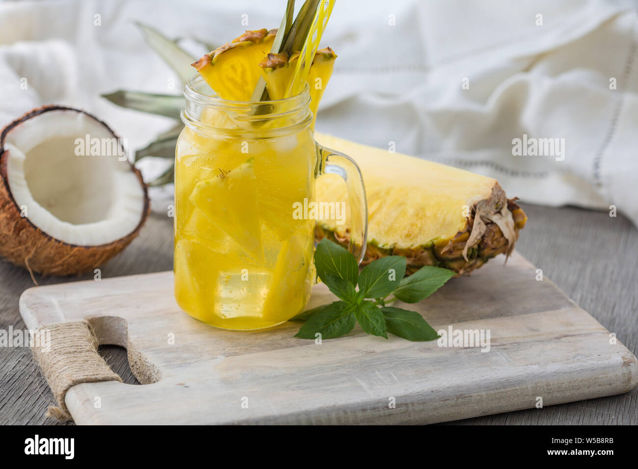 Accueil fizzy drink avec de la glace et de l'ananas sur un fond clair, selective focus. Photo de boisson rafraîchissante faite maison Banque D'Images