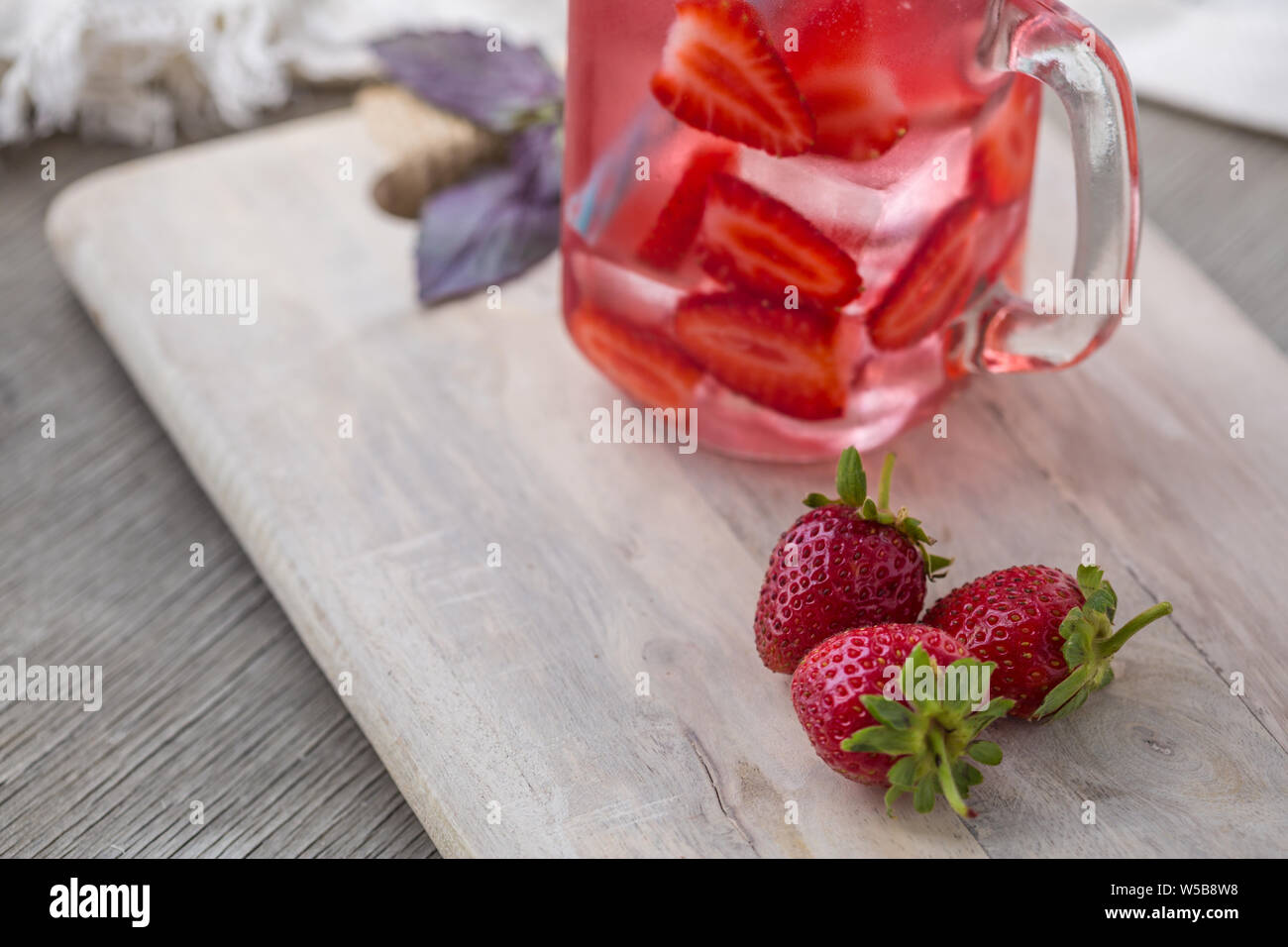 Accueil fizzy drink avec de la glace et de fraise sur un fond clair, selective focus. Photo de boisson rafraîchissante faite maison Banque D'Images