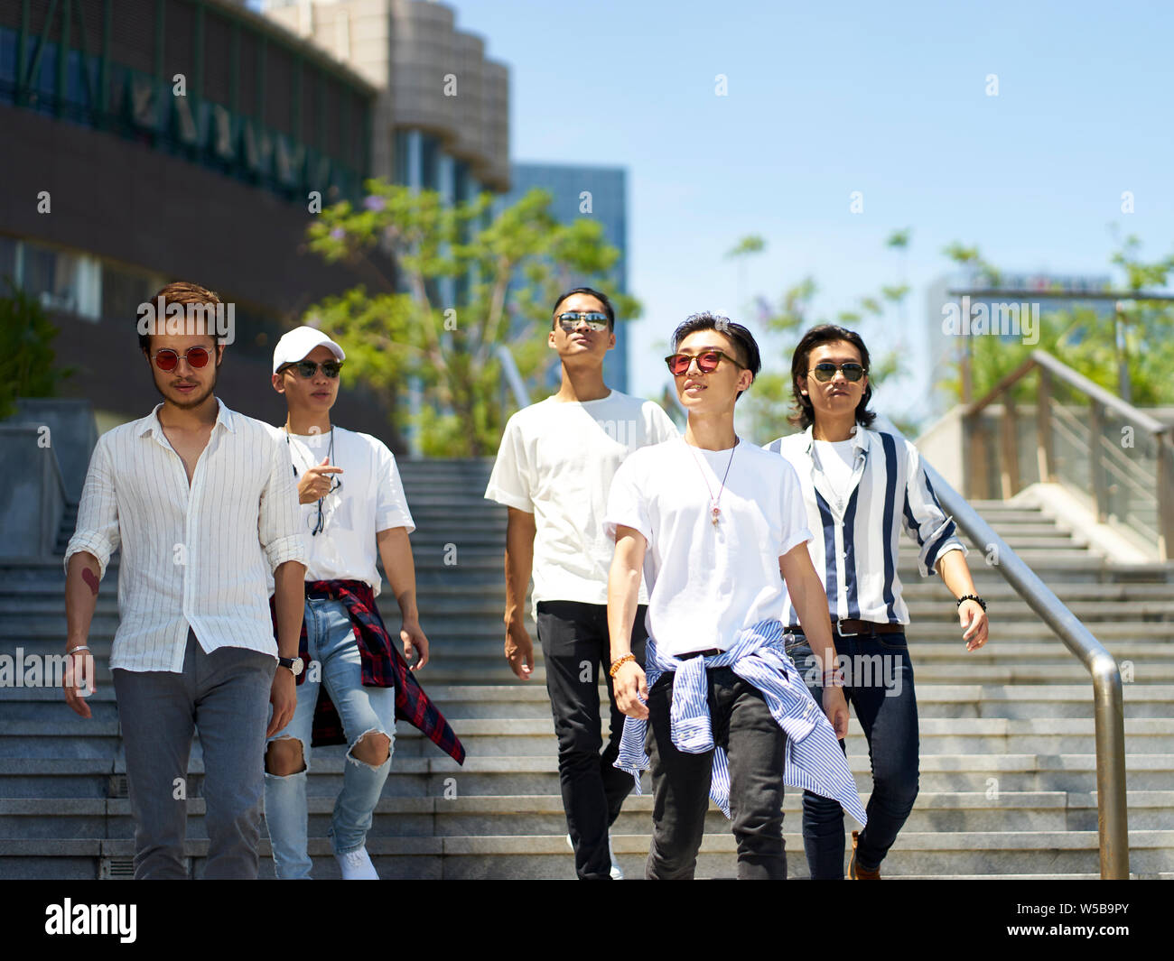 Un groupe de cinq jeunes adultes asiatiques traînant ensemble walking on street Banque D'Images