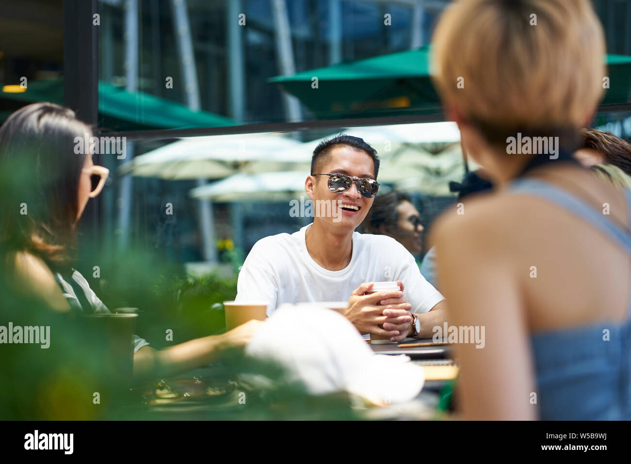Les jeunes gens d'Asie man and woman relaxing bavarder dans un café en plein air Banque D'Images