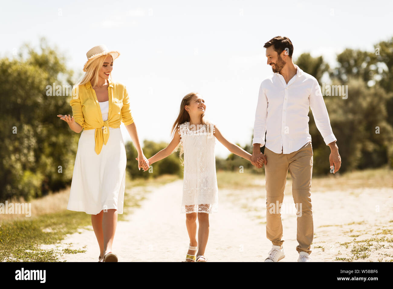 Happy Family walking on path holding hands Banque D'Images