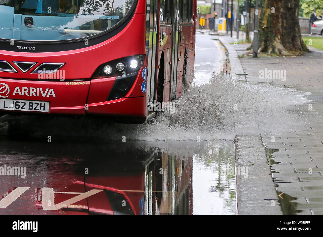 Londres, Royaume-Uni. 27 juillet, 2019. Un bus de l'eau éclabousse comme il se conduit par une inondation sur chemins verts dans le nord de Londres, causé par une forte averse dans la nuit. Credit : ZUMA Press, Inc./Alamy Live News Banque D'Images