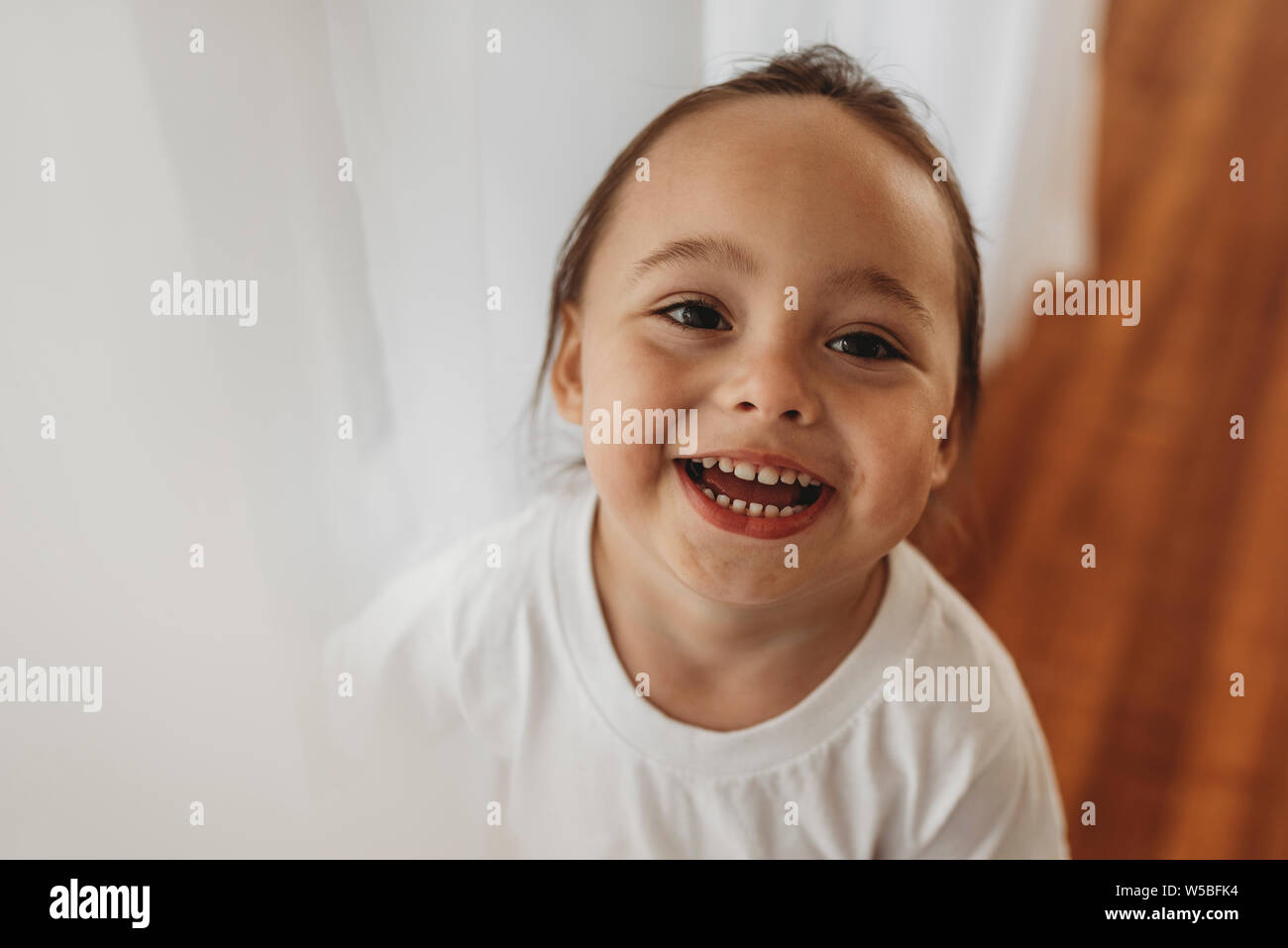 Portrait de jeune garçon à la caméra et au rire en studio Banque D'Images