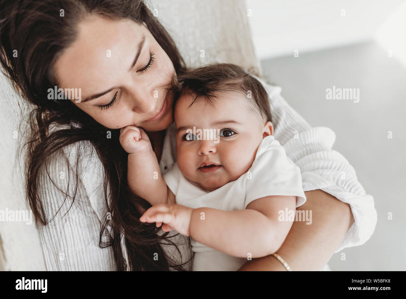 Mère et fille de bébé de câlins en hamac dans la lumière naturelle studio  Photo Stock - Alamy