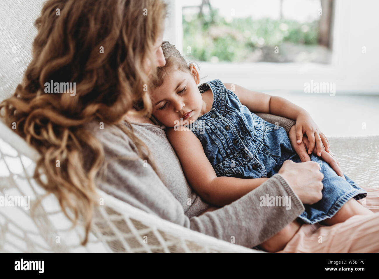 Jeune fille et mère de câliner le hamac dans la lumière du studio Banque D'Images