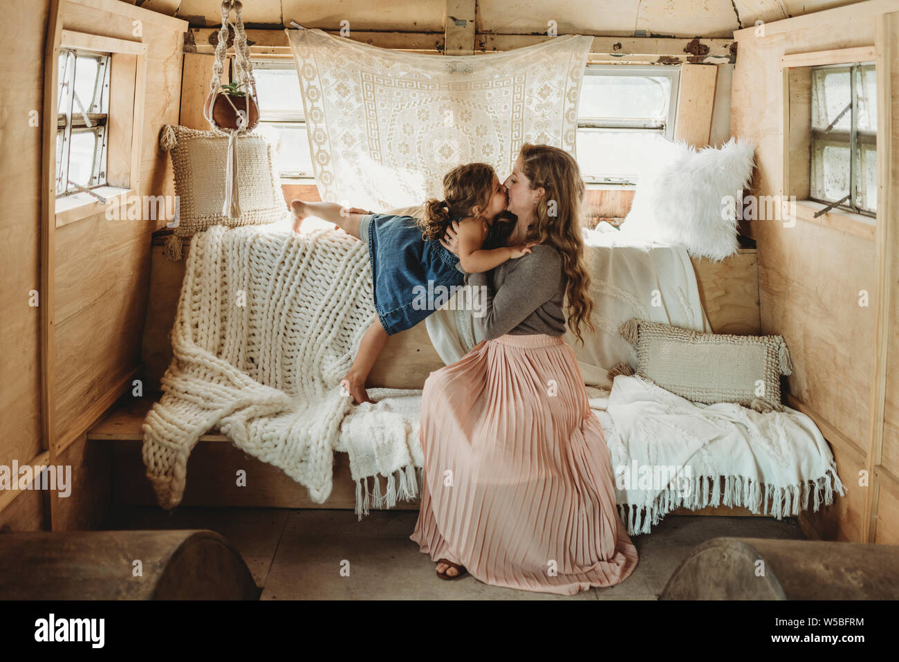 Mère et fille s'embrasser en configuration studio boho Banque D'Images